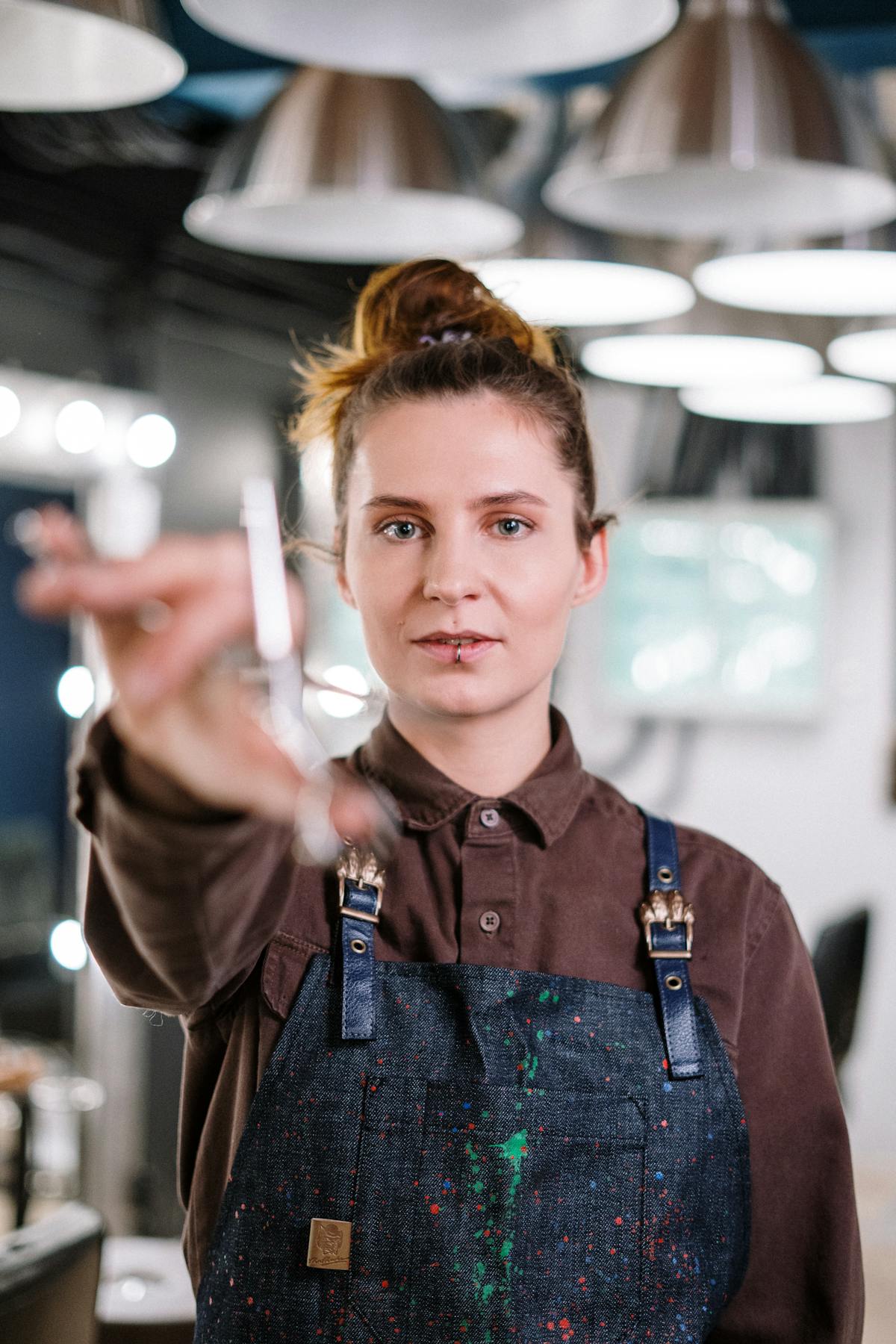 Coloriste au travail dans un salon lumineux — geste précis au pinceau de coloration